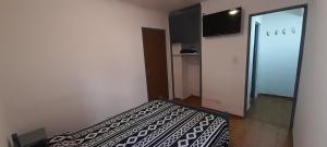 a bedroom with a bed with a black and white blanket at Hospedaje Alicia in Barraquero +5 photos