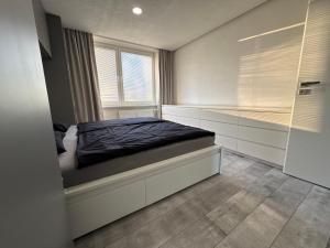 a bedroom with a bed and a window at Urban apartment in Spišská Nová Ves