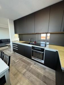 a kitchen with black cabinets and a sink at Urban apartment in Spišská Nová Ves