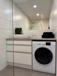 a white kitchen with a washing machine in it at Urban apartment in Spišská Nová Ves