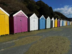 a row of colorful beach huts parked in a row at SOBO Studio in Bournemouth