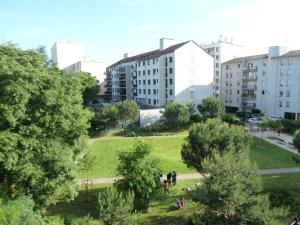 ヴィルールバンヌにあるMaisons Neuves/Montchatの建物が立ち並ぶ都市の中の公園