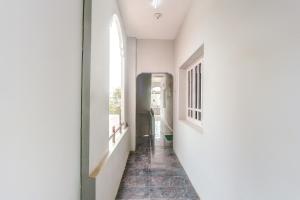 Un pasillo con una pared blanca y una ventana. en Hotel O Vivekam Home Stay, en Coimbatore