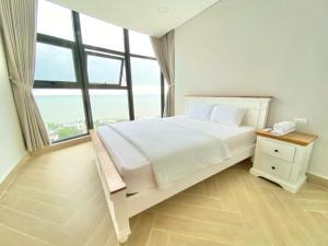 une chambre avec un lit et une grande fenêtre dans l'établissement Căn hộ du lịch 2PN Resort biển Long Cung 30m ra đến biển, hồ bơi, bãi biển riêng, à Vung Tau 18 autres photos