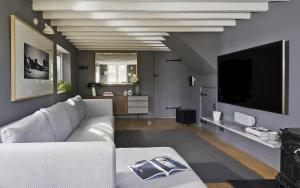 a living room with a white couch and a tv at 3 Bedrooms, 3 Double Beds, 6 Guests, Countryside Thatched Cottage in Four Marks