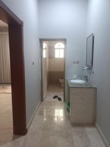 a bathroom with a sink and a toilet and a mirror at صحلنىوت الجنوبية in Salalah