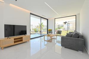 ein Wohnzimmer mit Flachbildfernseher und Couch in der Unterkunft Kalma Luxury Living Suites Heraklion in Iraklio