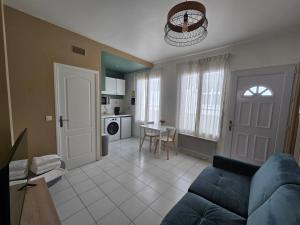 イシー・レ・ムリノーにあるAppartement spacieux 28m2 avec chambre séparéeの青いソファとキッチンのあるリビングルーム