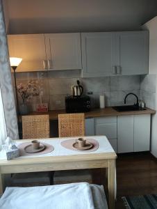 a kitchen with a table with two cups on it at Nocleg Pod Gubałówką in Zakopane