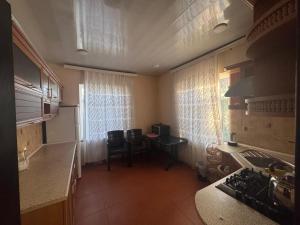a kitchen with a table and a kitchen with a window at villa pirşağı in Bilgah