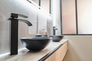 a bathroom with two sinks and two faucets on a counter at La douce parenthèse in Laon