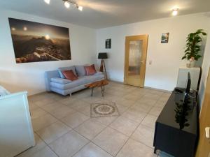 a living room with a couch and a painting on the wall at Ferienwohnung Bergliebe in Füssen