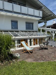 a house with a balcony and two chairs on a patio at Ferienwohnung Bergliebe in Füssen