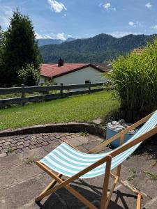 a chair sitting on a patio with mountains in the background at Ferienwohnung Bergliebe in Füssen +2 photos