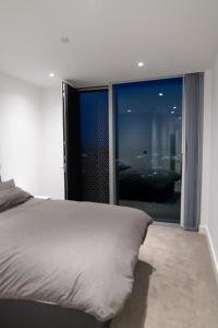 a bedroom with a bed and a large window at Modern 2 Bed Penthouse with Stunning views in Manchester City Center in Manchester