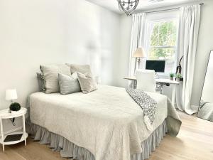a white bedroom with a bed and a desk at Soul Beach Lake House in Chapin