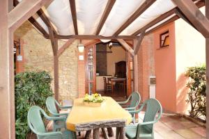 a wooden table and chairs on a patio at Villa Bolgherello in Marina di Bibbona