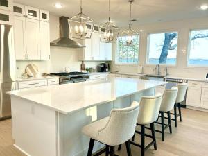 a kitchen with a large white island with bar stools at Soul Beach Lake House in Chapin