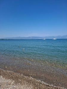a beach with boats in the water on a clear day at Xrisa Apartments in Petalidi