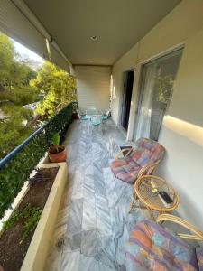 a balcony with a table and chairs on a balcony at Varkiza Beach Entire Apartment in Vari