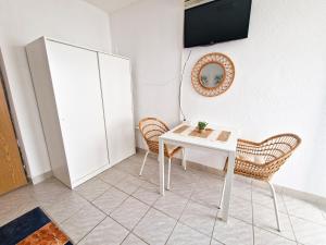 ein Zimmer mit einem Tisch und zwei Stühlen und einem Fernseher in der Unterkunft Villa Dusper in Trogir