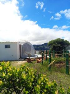 una tienda blanca en un campo con una valla en Hospedaje Mafer, en Guatavita