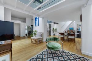 a living room with a tv and a chair and a table at Secret Loft Paris Zénith in Paris