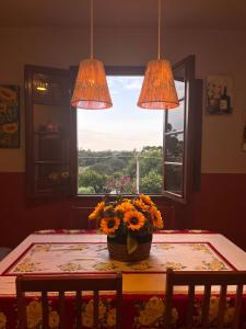 a table with a vase of flowers on a table with a window at Casa Nona Chema in Bento Gonçalves +40 photos
