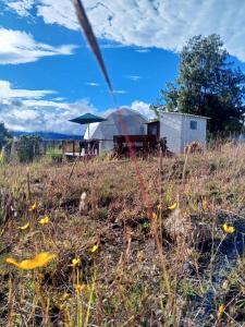 a field of grass with a tent in the background at Hospedaje Mafer in Guatavita