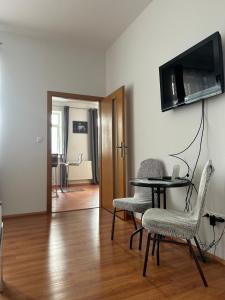 un salon avec une table, des chaises et une télévision dans l'établissement 4 May Plaza, à Bratislava