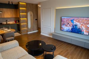 a living room with a large flat screen tv on a wall at Planet Imperial Apartman & SPA in Niš +65 photos