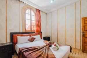 a bedroom with a bed with flowers on it at Riad Mazouz102 Médina in Marrakech