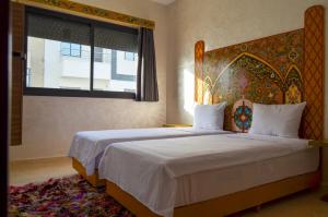 a bedroom with a bed with a headboard and a window at Appartement Nadine Fès in Fez
