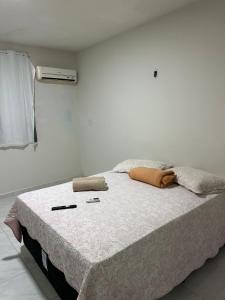 a bed in a white room with two pillows on it at Pousada Nova Betânia in Mossoró