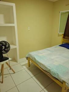a bedroom with a bed and a chair in it at Casa em Paracuru a 5 minutos (de carro) do centro. in Paracuru +29 photos