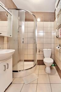 a bathroom with a shower and a toilet and a sink at CLIFF House in Międzyzdroje
