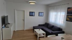 a living room with a blue couch and a table at Damir A4 in Selce