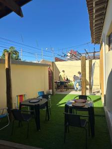 a patio with two tables and chairs on the grass at Pousada Nova Betânia in Mossoró