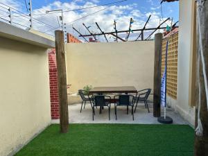 a table and chairs on a patio with grass at Pousada Nova Betânia in Mossoró