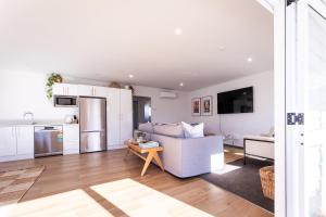 a kitchen and living room with a couch and a table at Under the Oak in Greytown