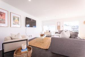 a living room with two couches and a table at Under the Oak in Greytown