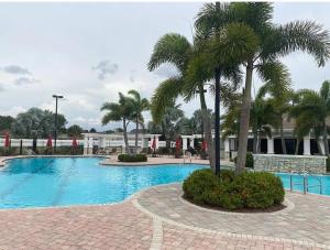 a swimming pool with a palm tree in front of a building at Townhouse Retreat in Riverview +20 photos