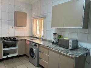 MamaPeridot Apartment Central Area, Abuja的带水槽和洗衣机的厨房 更多2张照片
