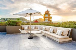 卡波圣卢卡斯Amazing 2 Bdrm condo near medano beach的庭院里设有白色的沙发和遮阳伞。