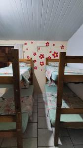 a room with four bunk beds and flowers on the wall at Canoa Hostel in Canoa Quebrada