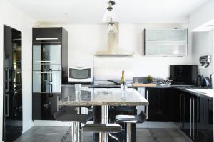 a kitchen with black cabinets and a marble counter top at Maison rayons de soleil in Bagnères-de-Bigorre
