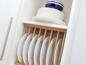 a bunch of plates and bowls on a shelf in a kitchen at Kitcat Cottage in Dartmouth