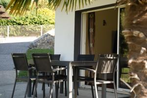 a dining table and chairs in front of a house at Maison rayons de soleil in Bagnères-de-Bigorre +3 photos