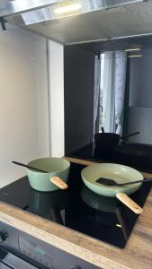 Zwei Schüsseln stehen auf einem Küchenherd. in der Unterkunft Hebergement DEUX pièces en résidence propre et calme in Lieusaint + 31 Fotos