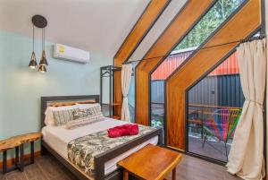 a bedroom with a bed and a large window at Aloki Kalok 3 - Refugio cerca de la playa in Talamanca
